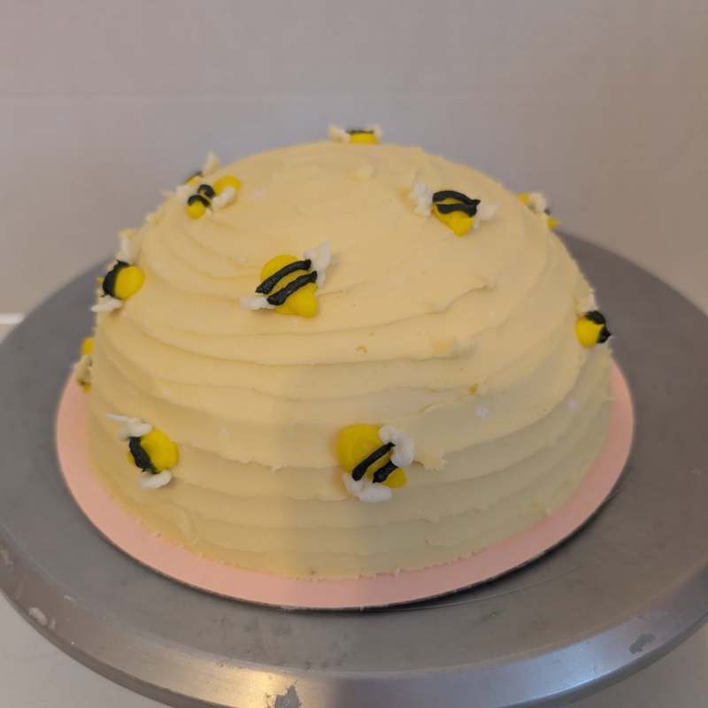 Bee-themed smash cake with matching cupcakes for a first birthday