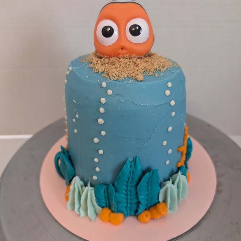 Whimsical owl-themed birthday cake with hand-piped feather details