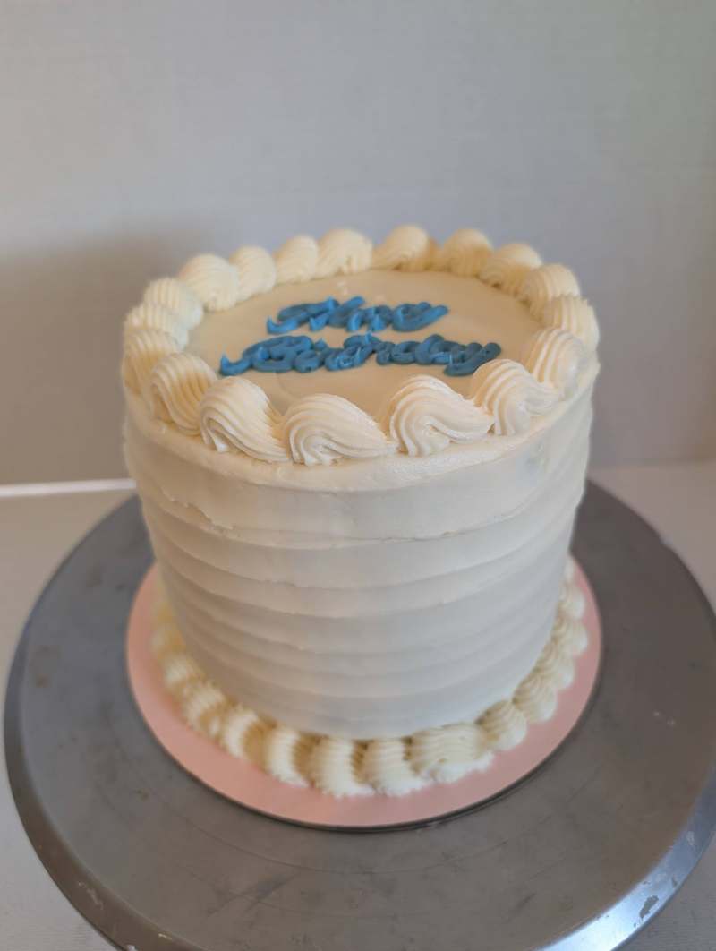 White buttercream birthday cake with piped swirls